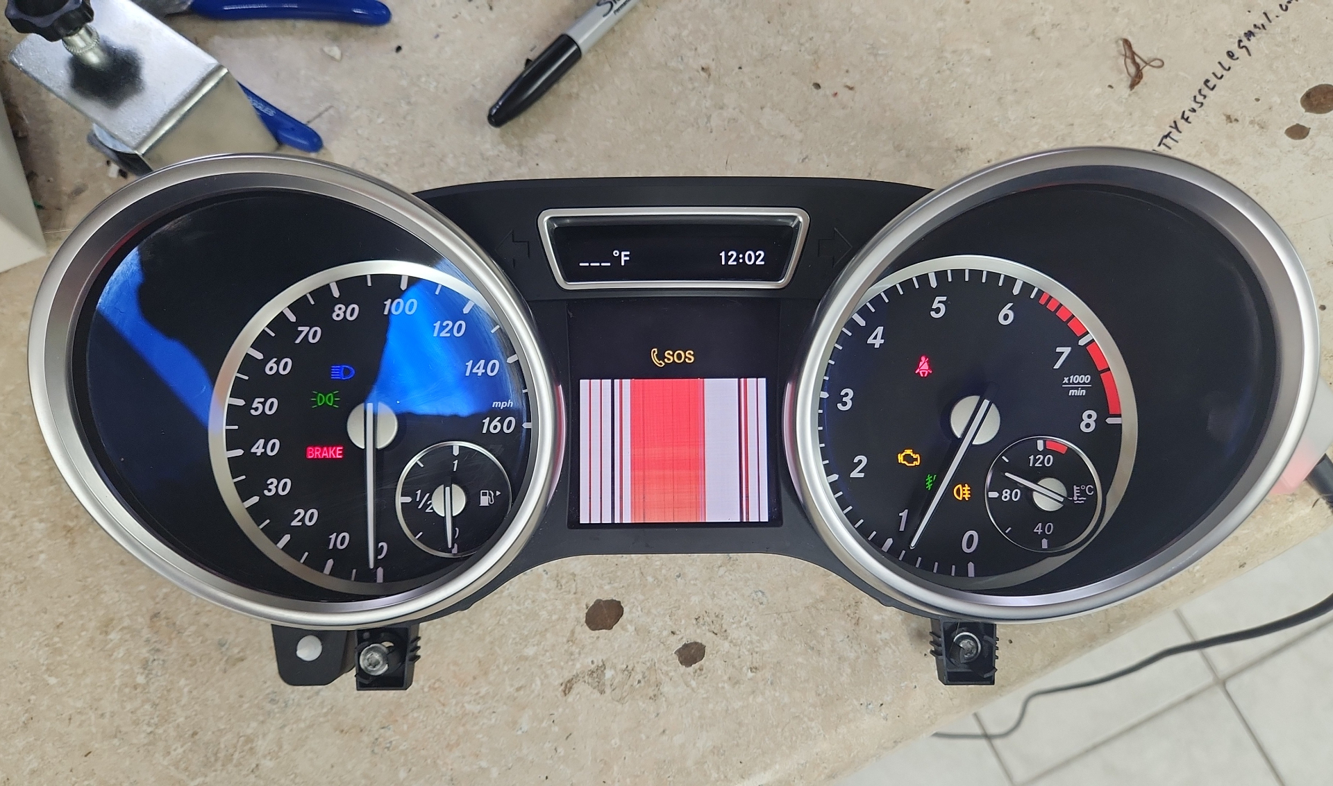 Mercedes instrument cluster with faulty LCD showing SOS and warning lights